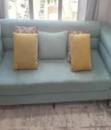 Mint green colored 3 Seater Sofa with additional 5 pillows of different shapes and sizes